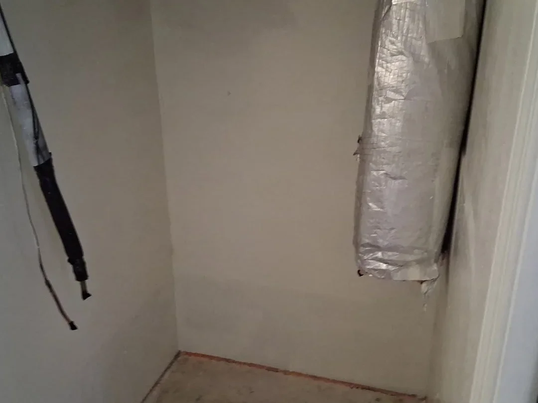 Drywall walls with foam-wrapped copper pipes and reflective insulation material installed